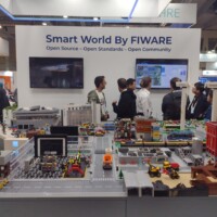 A photo of a cityscape built by lego at a stand in an expo area called Smart World by FIWARE