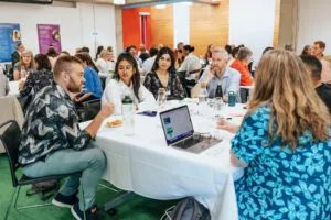 Conversation between a group of 6 people sat around a table during the conference event