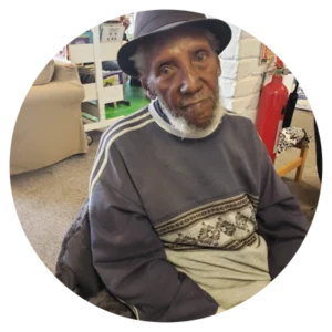 Image of a man from Guyana sat on a chair 