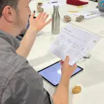 a man is explaining something on a piece of paper to a group at a table a man is explaining something on a piece of paper to a group at a table