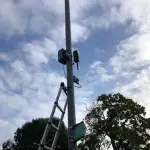 A photo of a street lamp post with a sensor attached to it